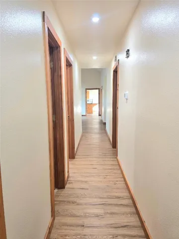 a view of a hallway with wooden floor