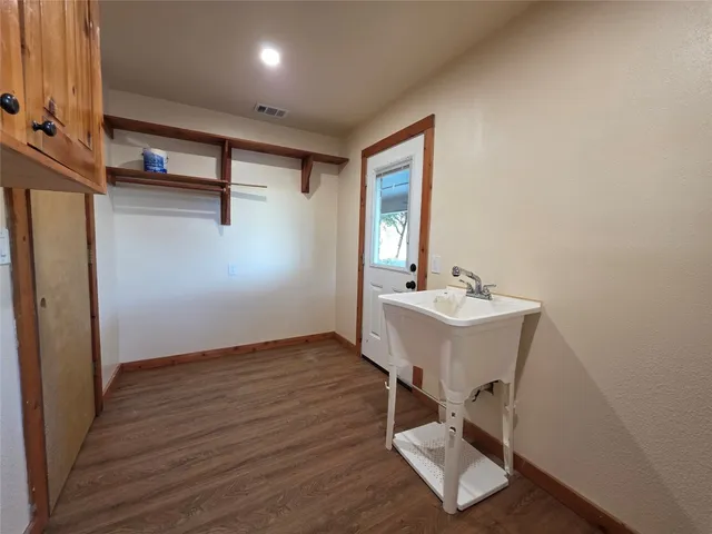a view of a hallway with wooden floor and workspace