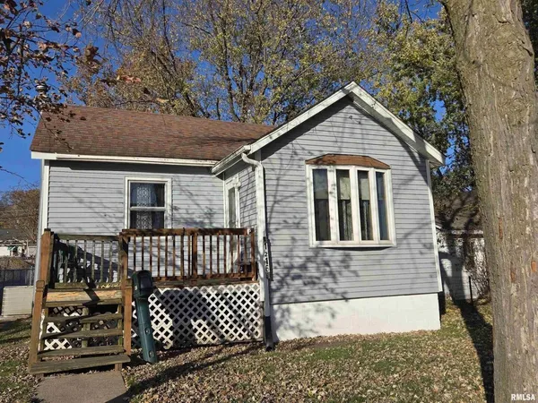 a view of a house with a small yard and wooden fence