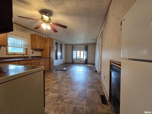 a view of a refrigerator in kitchen and a window