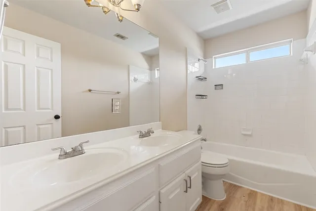 a bathroom with a granite countertop sink a toilet and shower