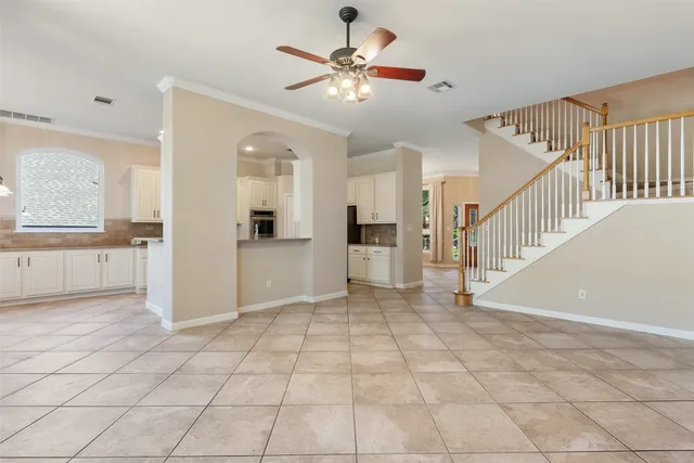 a view of a big room with entryway and chandelier fan