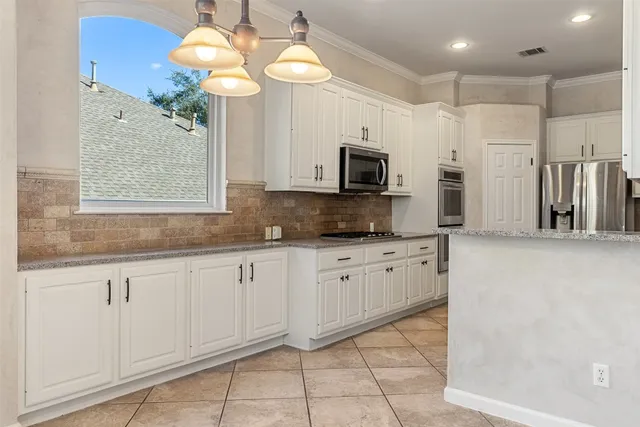 a kitchen with kitchen island granite countertop a stove a sink and a microwave