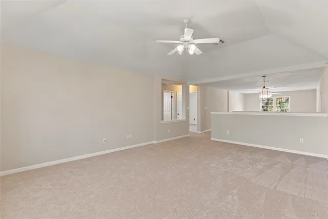a view of an empty room with a chandelier fan