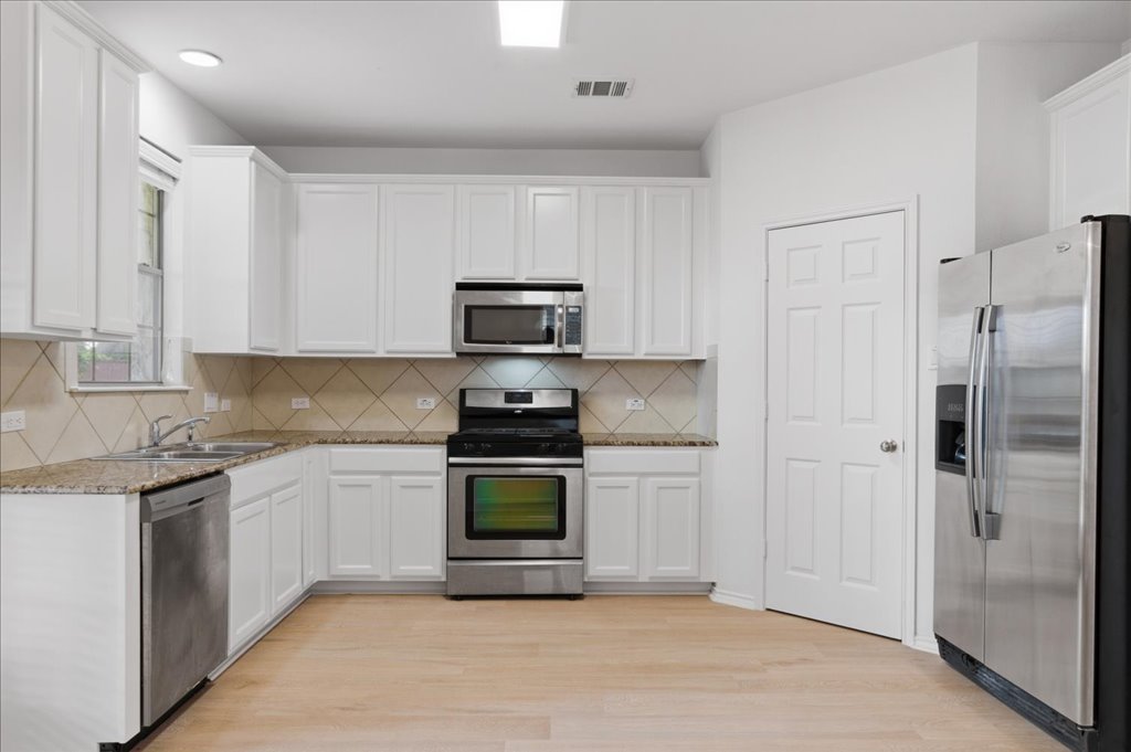 14815 Avery Ranch Boulevard, Unit 302 Austin, TX 78717 - Photo 3 of 30 a kitchen with stainless steel appliances granite countertop a refrigerator and a stove top oven