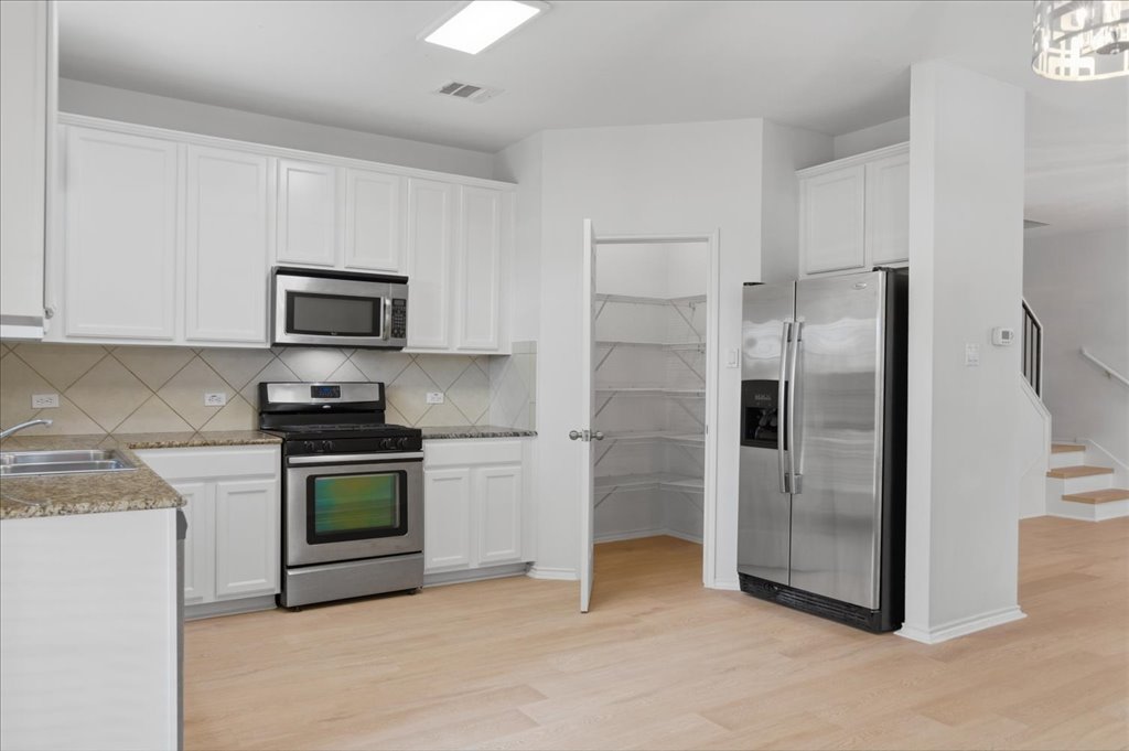 14815 Avery Ranch Boulevard, Unit 302 Austin, TX 78717 - Photo 6 of 30 a kitchen with stainless steel appliances granite countertop a refrigerator a stove a sink and a microwave