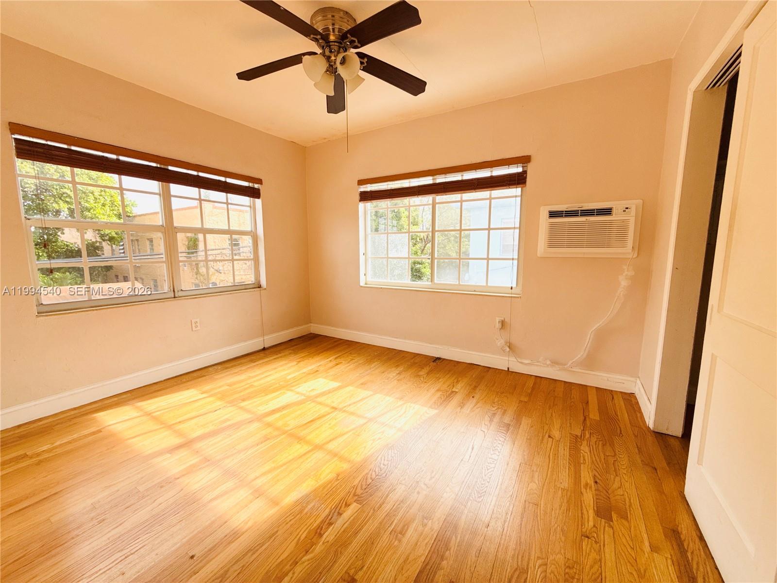 555 Southwest 16th Avenue, Unit 11 Miami, FL 33135 - Photo 13 of 18 a view of an empty room with wooden floor and a window