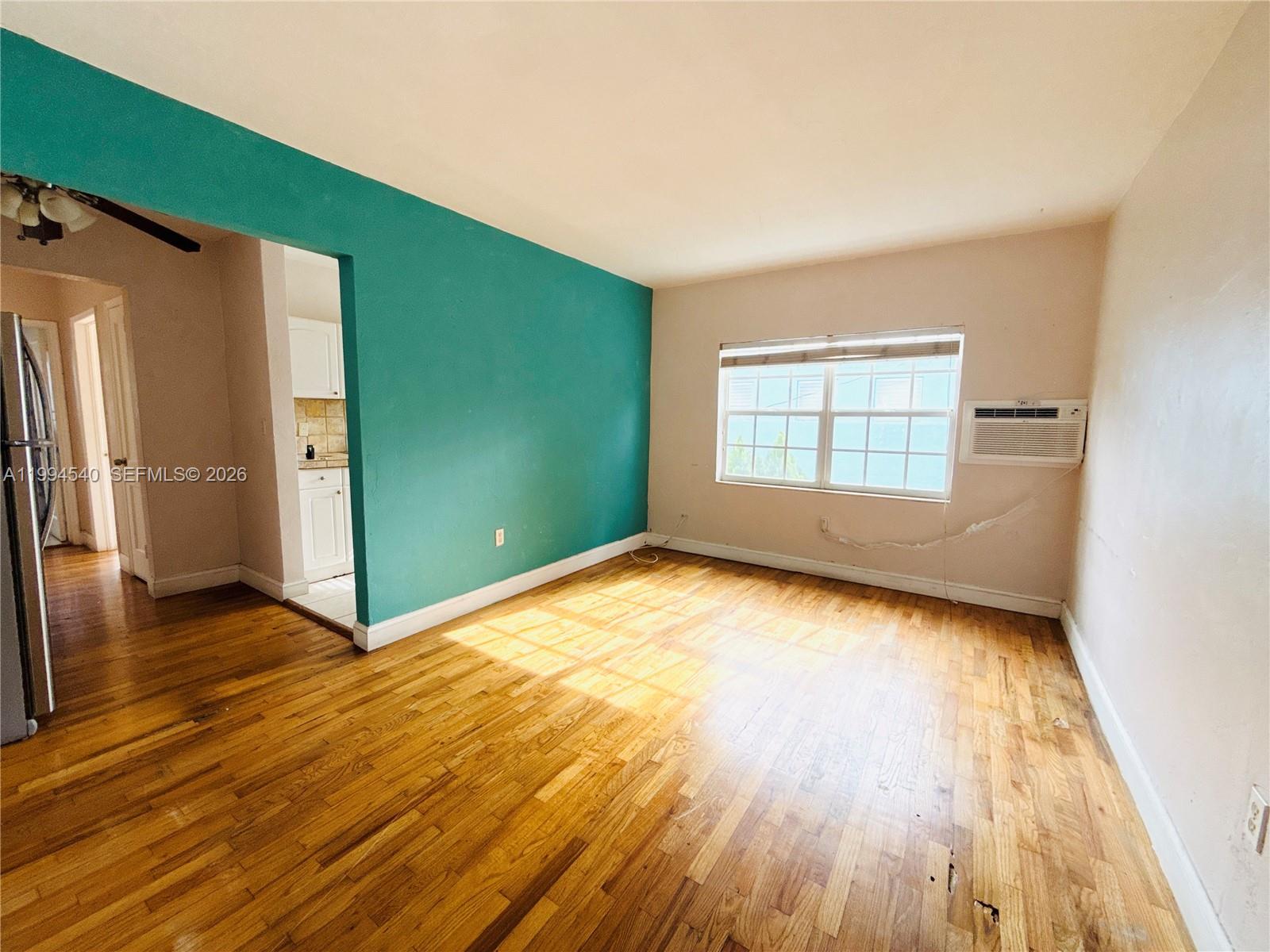 555 Southwest 16th Avenue, Unit 11 Miami, FL 33135 - Photo 3 of 18 an empty room with wooden floor and windows