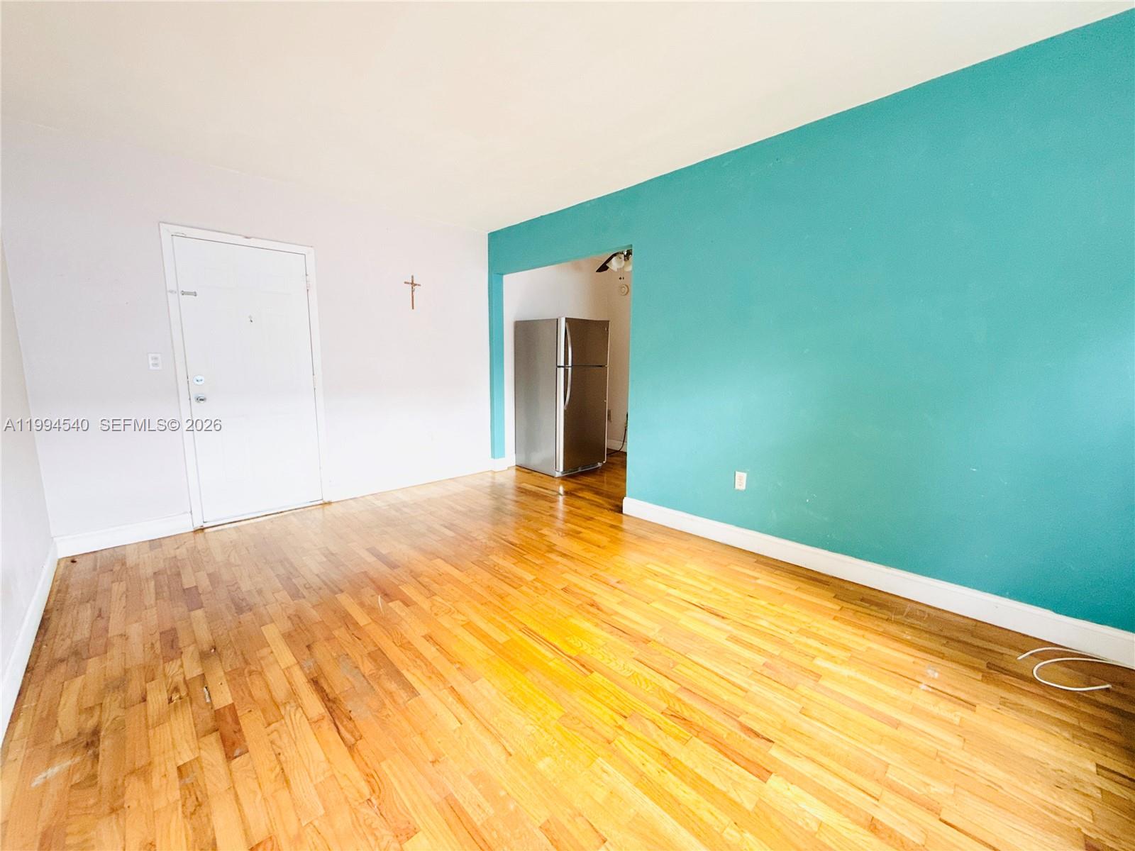 555 Southwest 16th Avenue, Unit 11 Miami, FL 33135 - Photo 4 of 18 a view of empty room with wooden floor