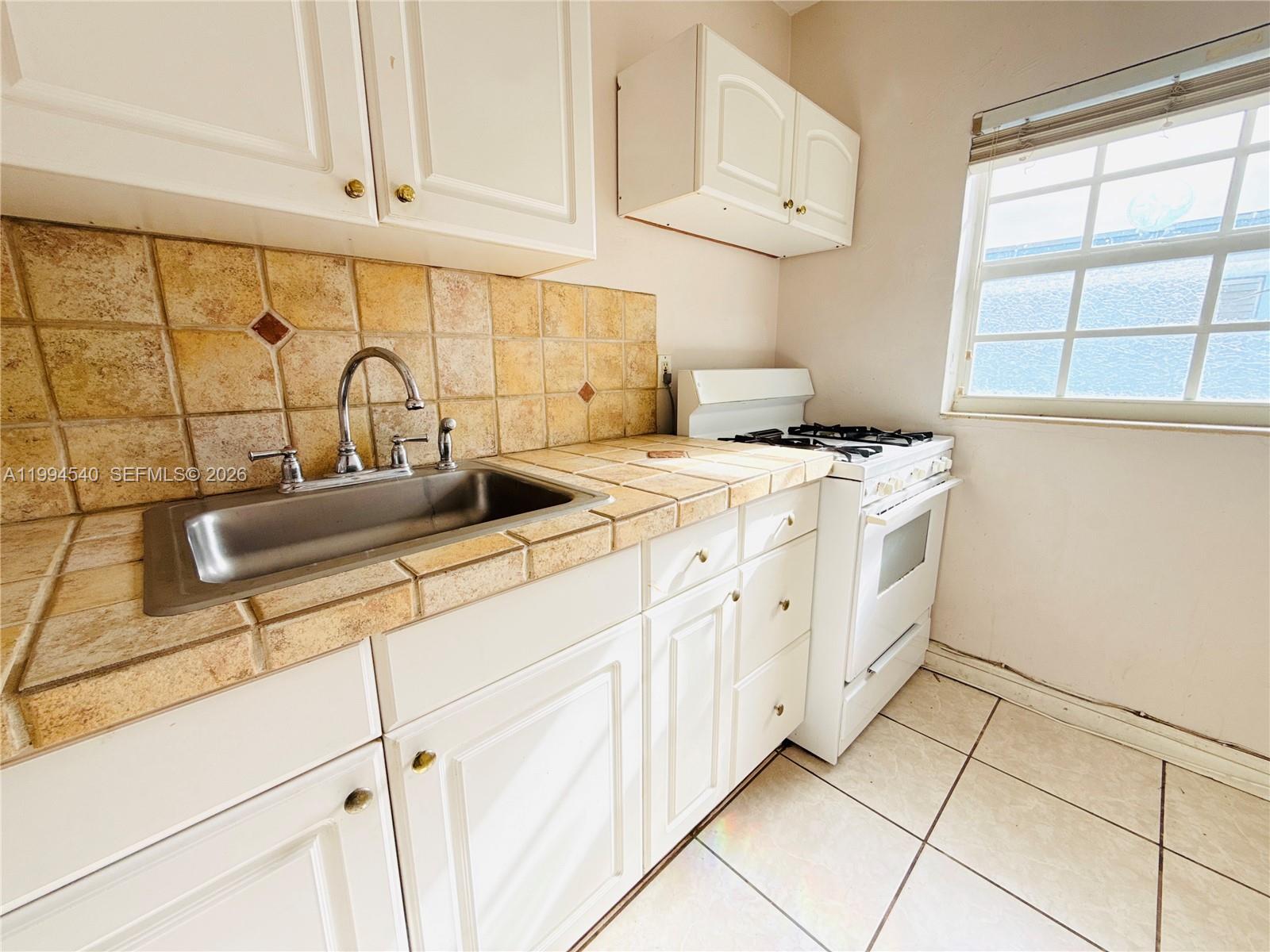 555 Southwest 16th Avenue, Unit 11 Miami, FL 33135 - Photo 7 of 18 a kitchen with stainless steel appliances granite countertop a sink and a stove