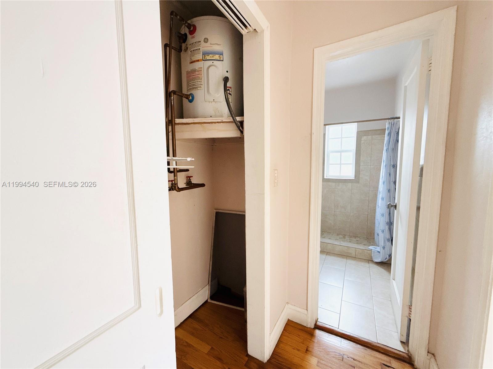 555 Southwest 16th Avenue, Unit 11 Miami, FL 33135 - Photo 10 of 18 a view of a hallway with wooden floor and a bathroom