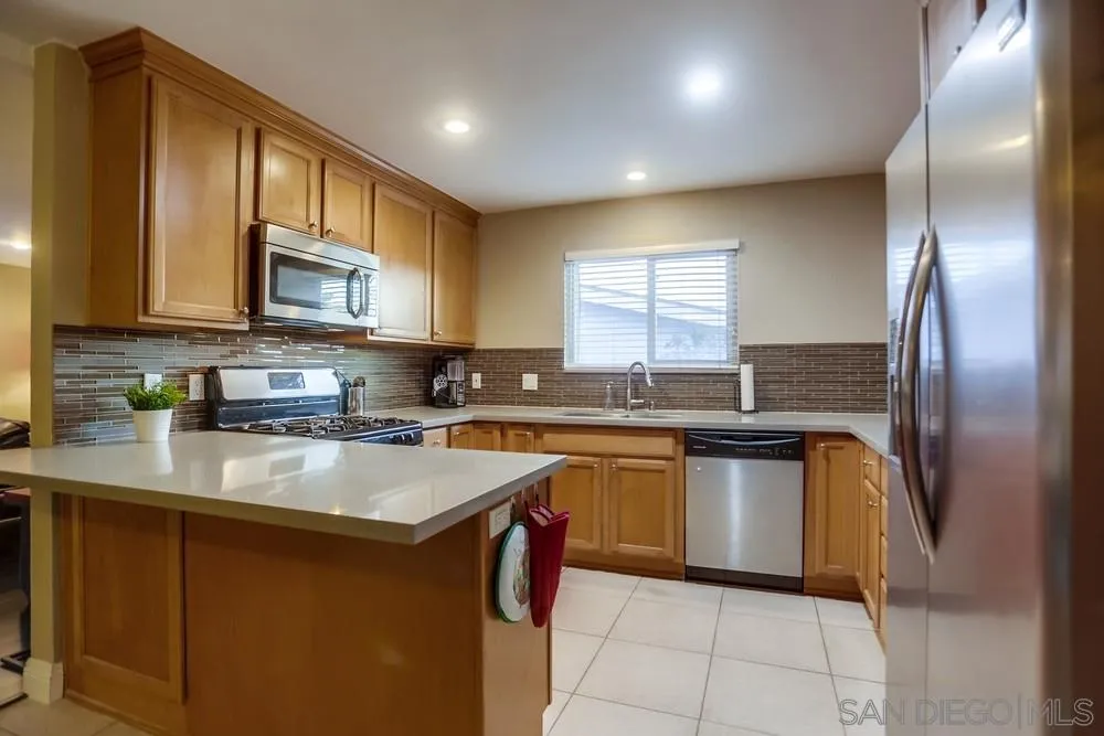 13626 Carriage Road Poway, CA 92064 - Photo 8 of 25 a kitchen with stainless steel appliances granite countertop a sink a stove a microwave a counter top space and cabinets