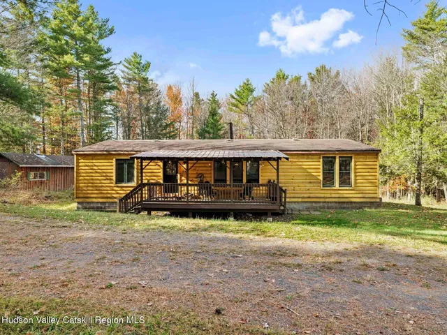 a view of a house with a yard and large trees