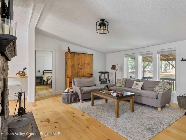 a living room with furniture wooden floor and a large window