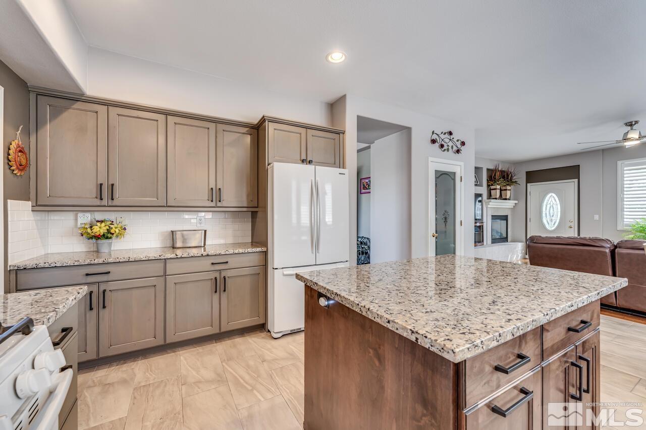 10650 Silver Cliff Way Reno, NV 89521 - Photo 12 of 38 a kitchen with stainless steel appliances granite countertop a sink dishwasher and refrigerator