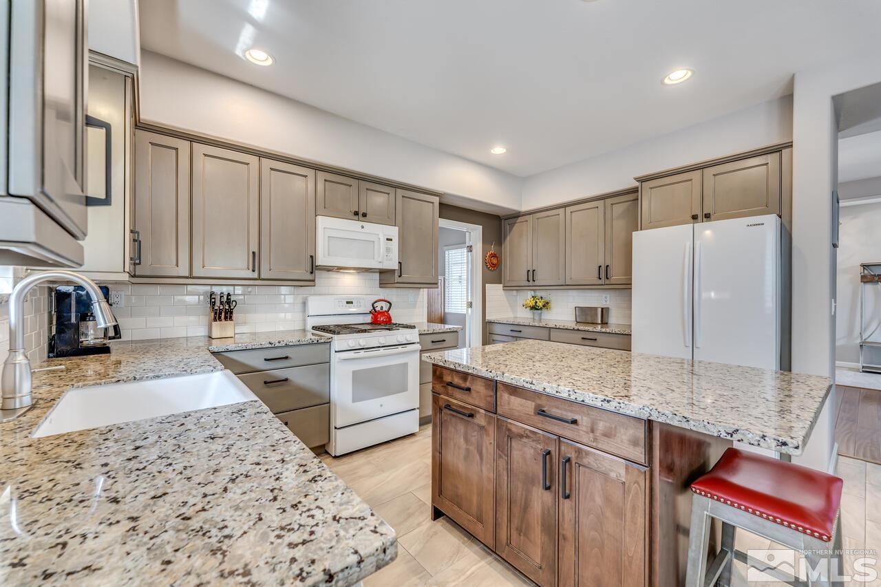 10650 Silver Cliff Way Reno, NV 89521 - Photo 13 of 38 a kitchen with stainless steel appliances granite countertop a stove refrigerator sink and cabinets