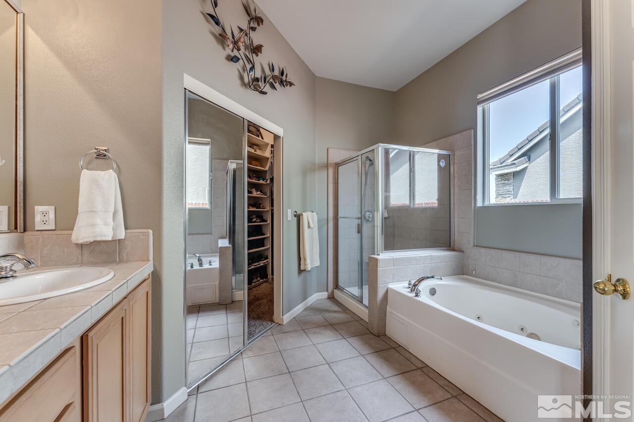 10650 Silver Cliff Way Reno, NV 89521 - Photo 19 of 38 a bathroom with a tub sink shower and mirror