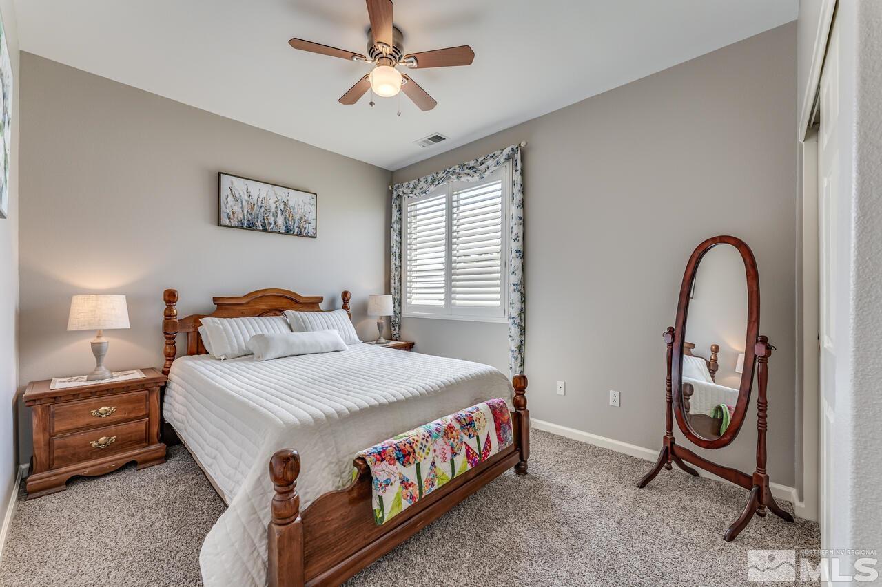 10650 Silver Cliff Way Reno, NV 89521 - Photo 26 of 38 a bedroom with a bed and a chandelier