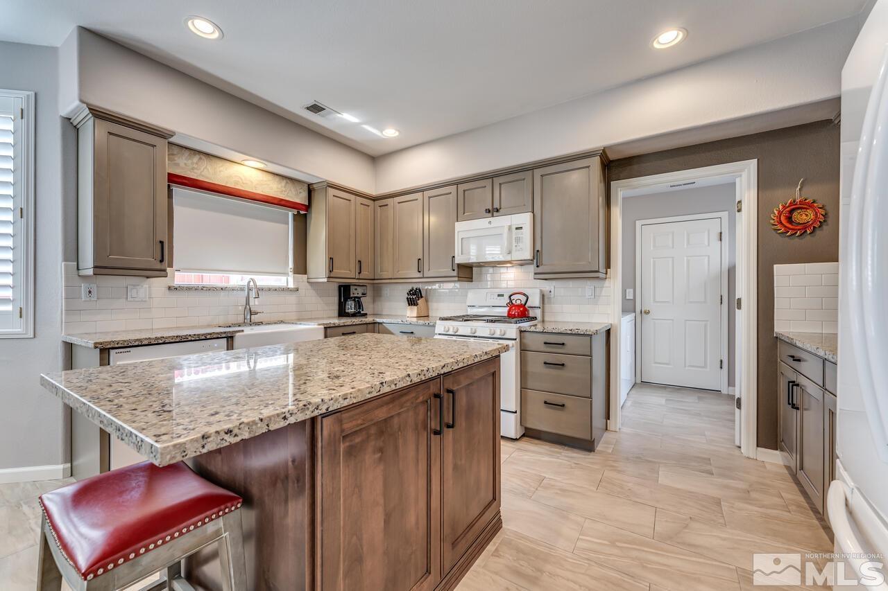 10650 Silver Cliff Way Reno, NV 89521 - Photo 10 of 38 a kitchen with stainless steel appliances granite countertop a sink stove and refrigerator