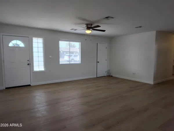 an empty room with windows and fan