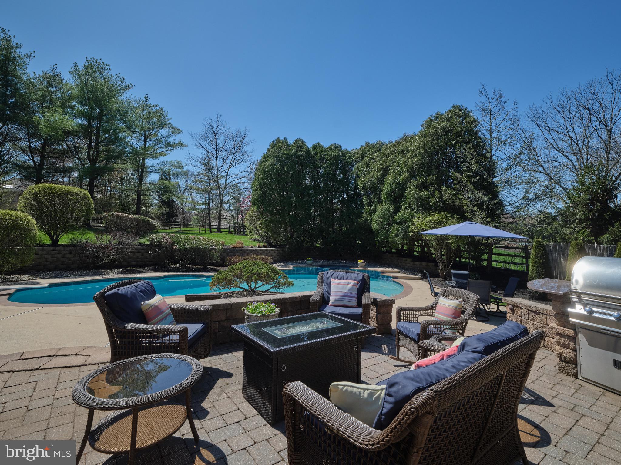 37 Alexanders Court Newtown, PA 18940 - Photo 3 of 50 a view of a patio with couches a table and chairs under an umbrella with a fire pit