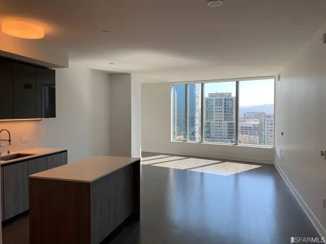 a view of kitchen with stainless steel appliances wooden floor and wooden cabinets
