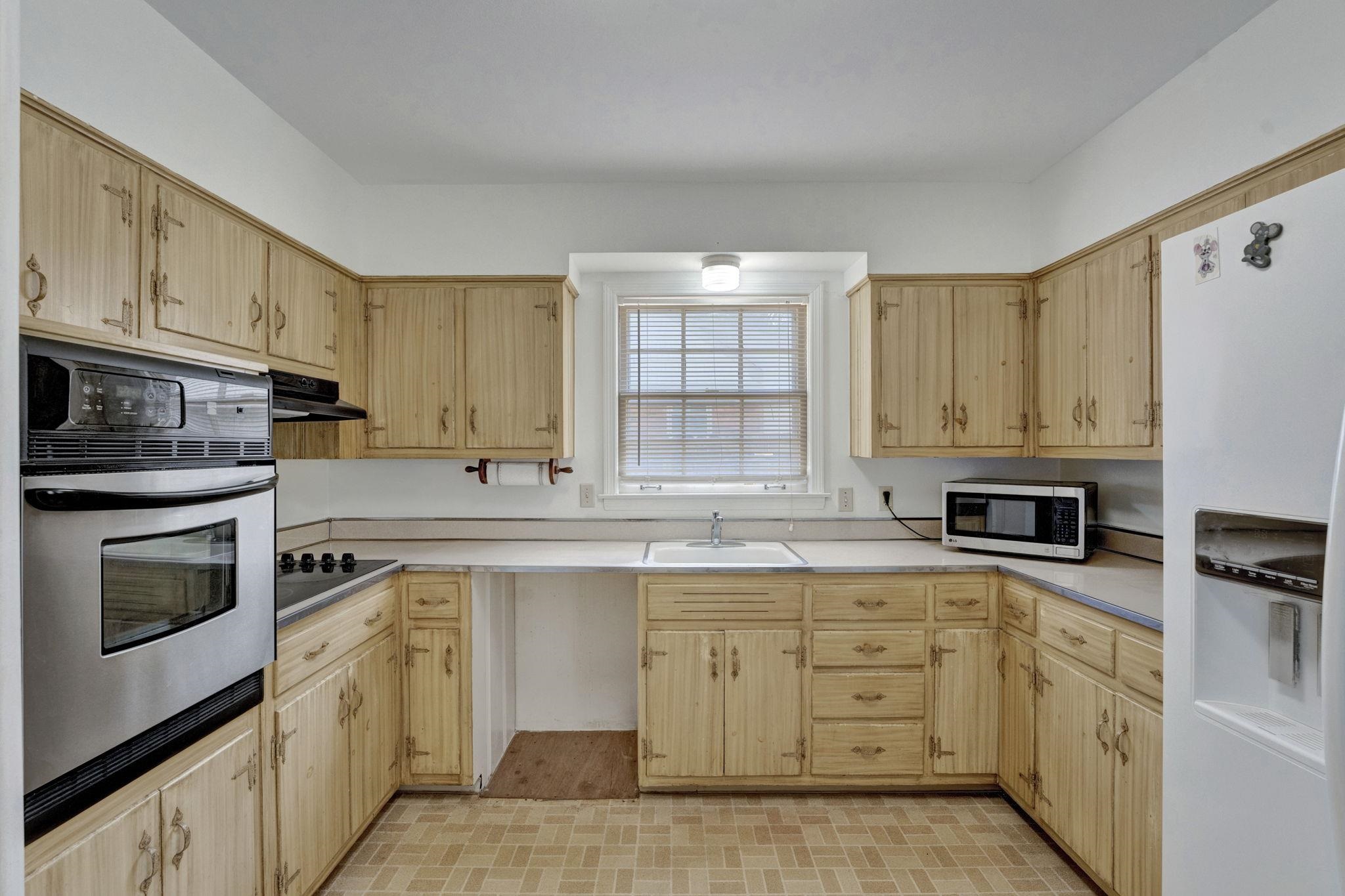 87 North Oak Grove Road Memphis, TN 38120 - Photo 8 of 25 a kitchen with cabinets stainless steel appliances and a window