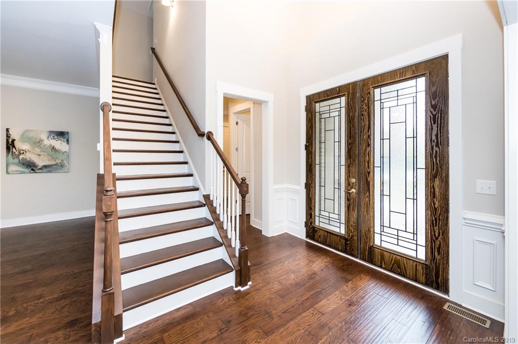 136 Streamwood Road, Unit 17 Troutman, NC 28166 - Photo 5 of 43 a view of a hallway with wooden floor and windows