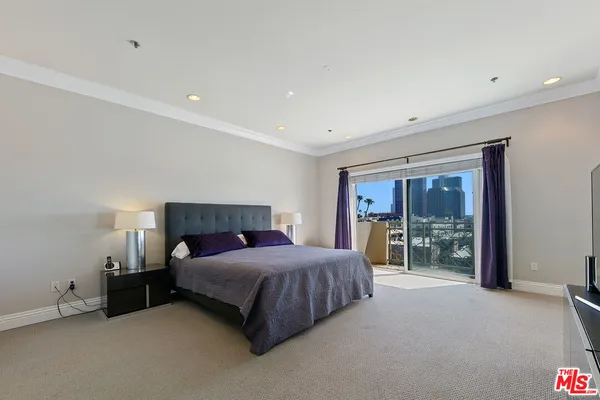 a bedroom with a bed and large window