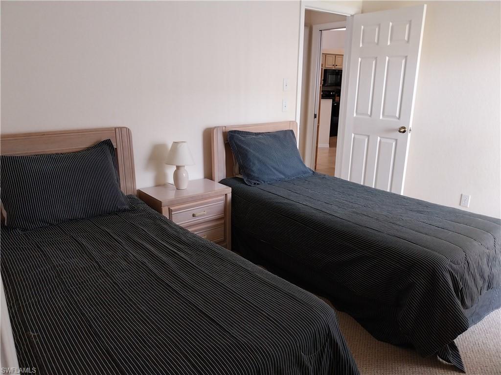 449 Dundee Court Naples, FL 34104 - Photo 23 of 35 a bedroom with a bed and wooden floor