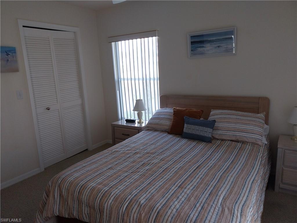 449 Dundee Court Naples, FL 34104 - Photo 27 of 35 a bedroom with a bed and wooden floor