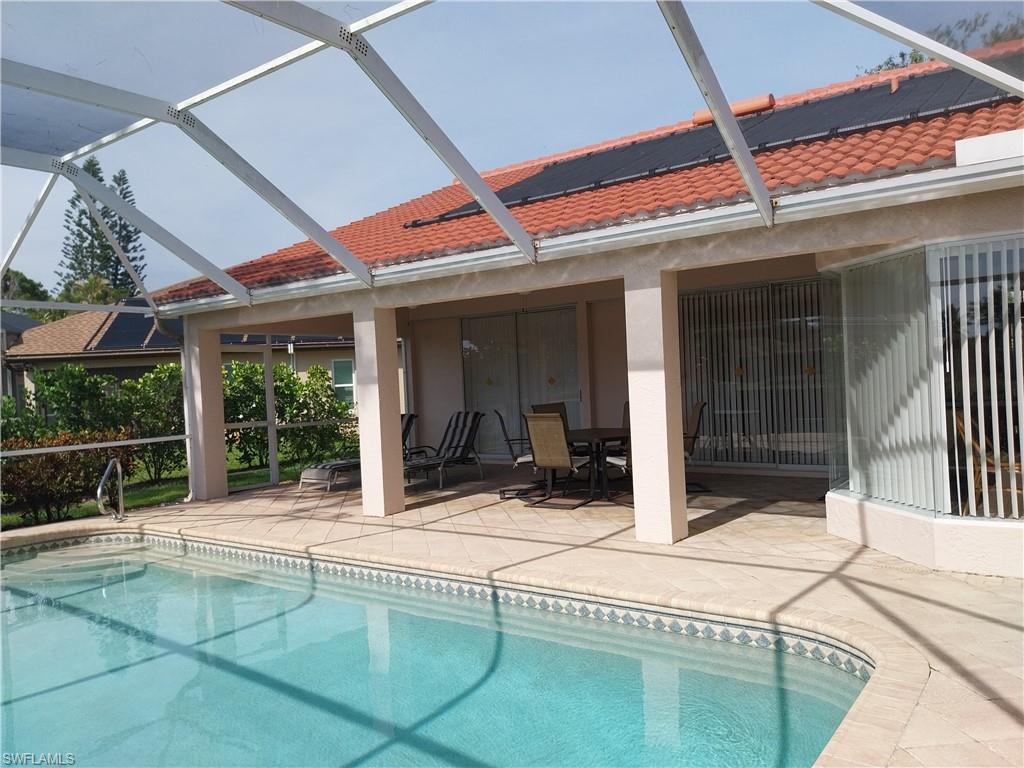 449 Dundee Court Naples, FL 34104 - Photo 29 of 35 Swimming pool with a patio area, glass enclosure, and outdoor dining area