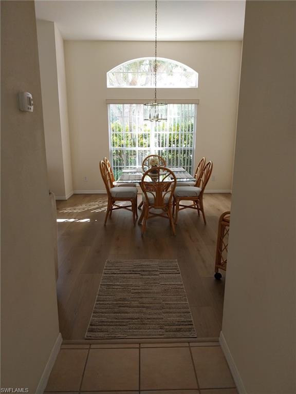 449 Dundee Court Naples, FL 34104 - Photo 8 of 35 Dining room featuring a chandelier and light wood finished floors