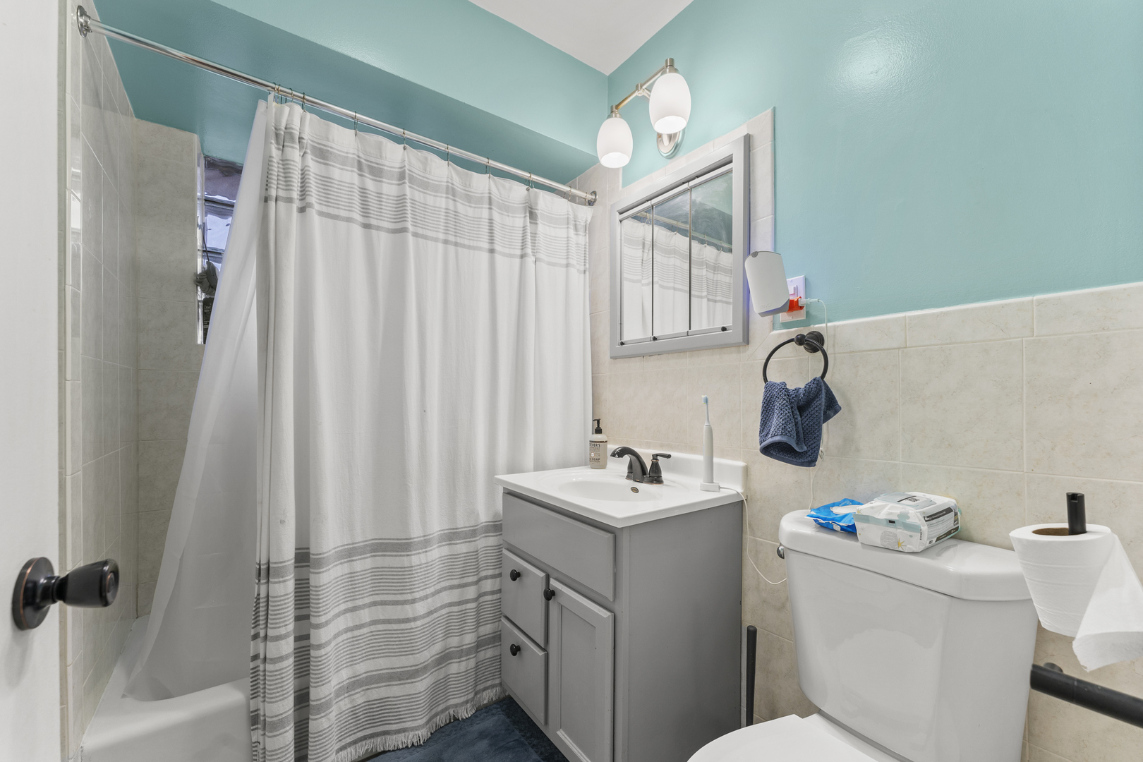 5121 West Diversey Avenue, Unit 3S Chicago, IL 60639 - Photo 6 of 9 a bathroom with a sink a toilet and shower curtain