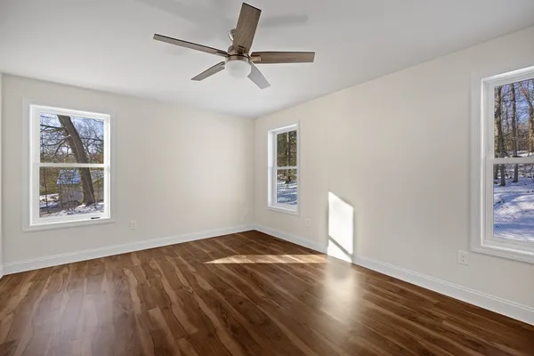 a view of empty room with wooden floor