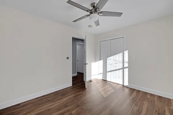 a view of a big room with wooden floor closet and windows