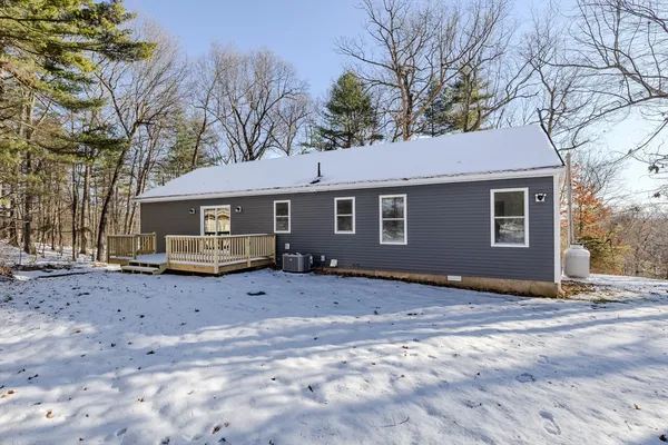 a front view of a house with a yard covered in snow