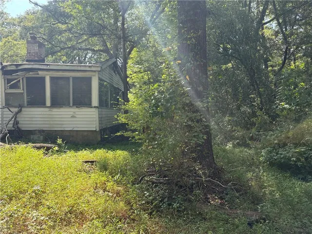 a view of a patio with table and chairs potted plants and large tree