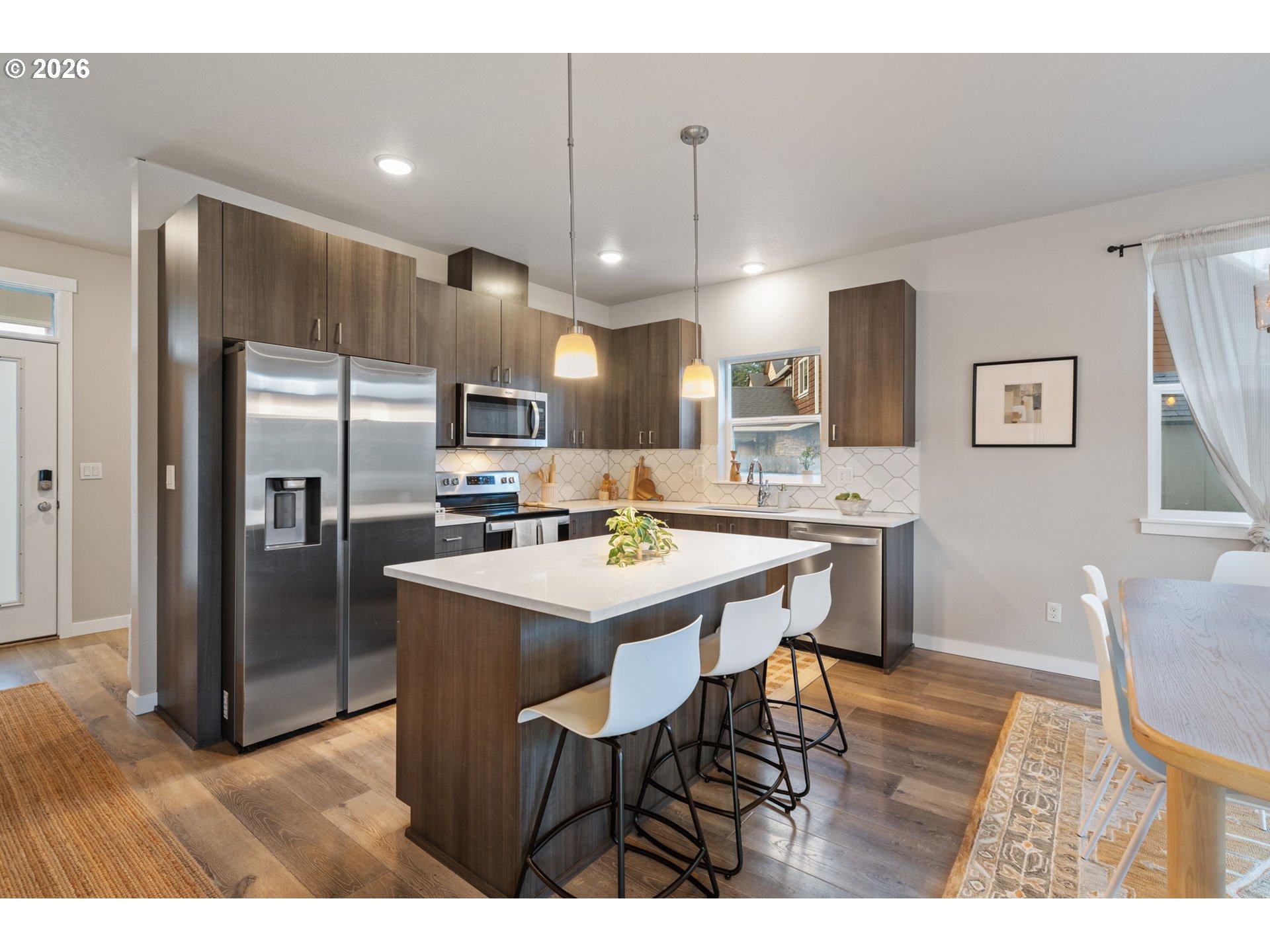 5706 Southeast 134th Place Portland, OR 97236 - Photo 13 of 39 a kitchen with refrigerator a sink and chairs