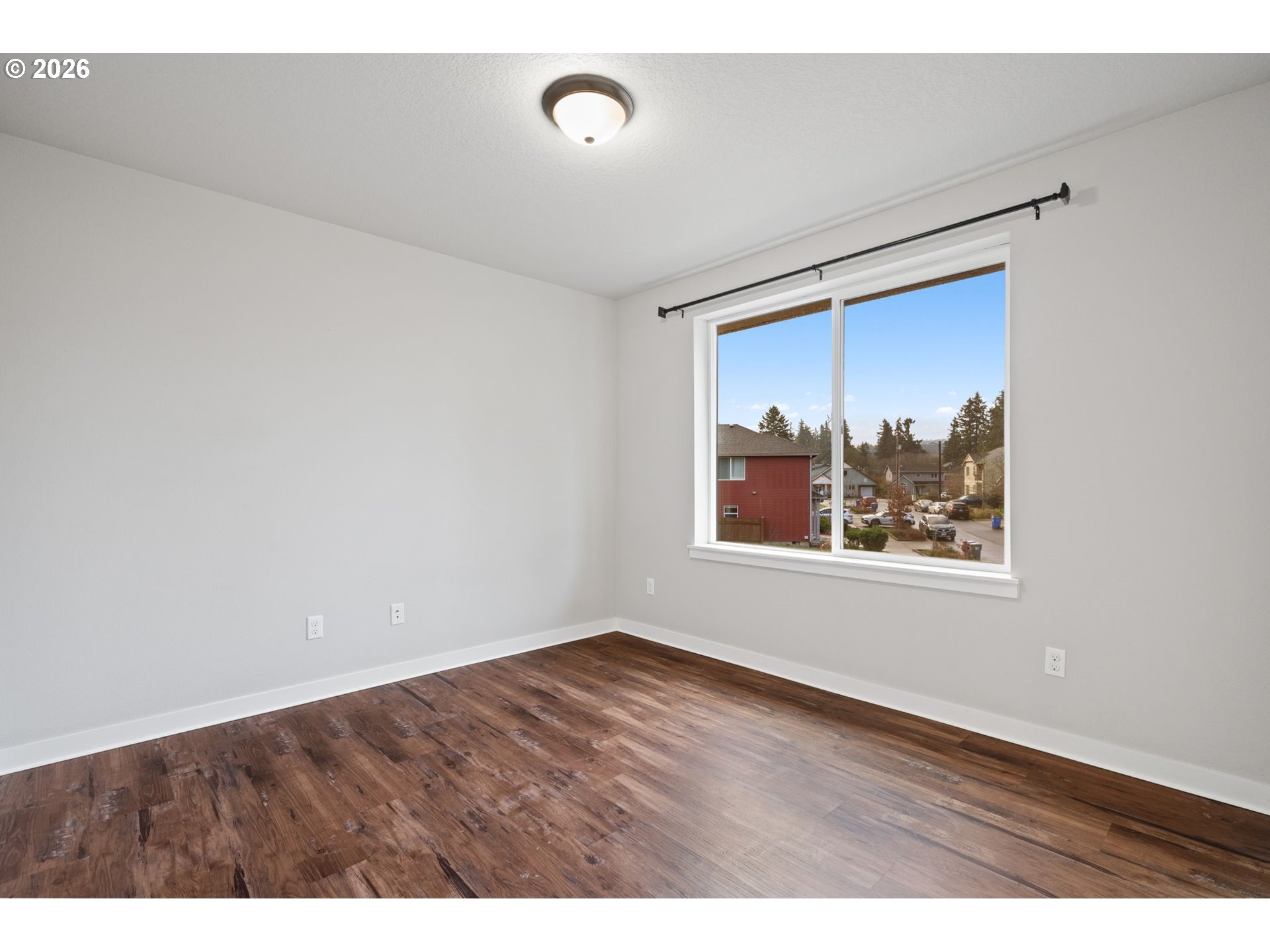 5706 Southeast 134th Place Portland, OR 97236 - Photo 27 of 39 a view of an empty room with wooden floor and a window