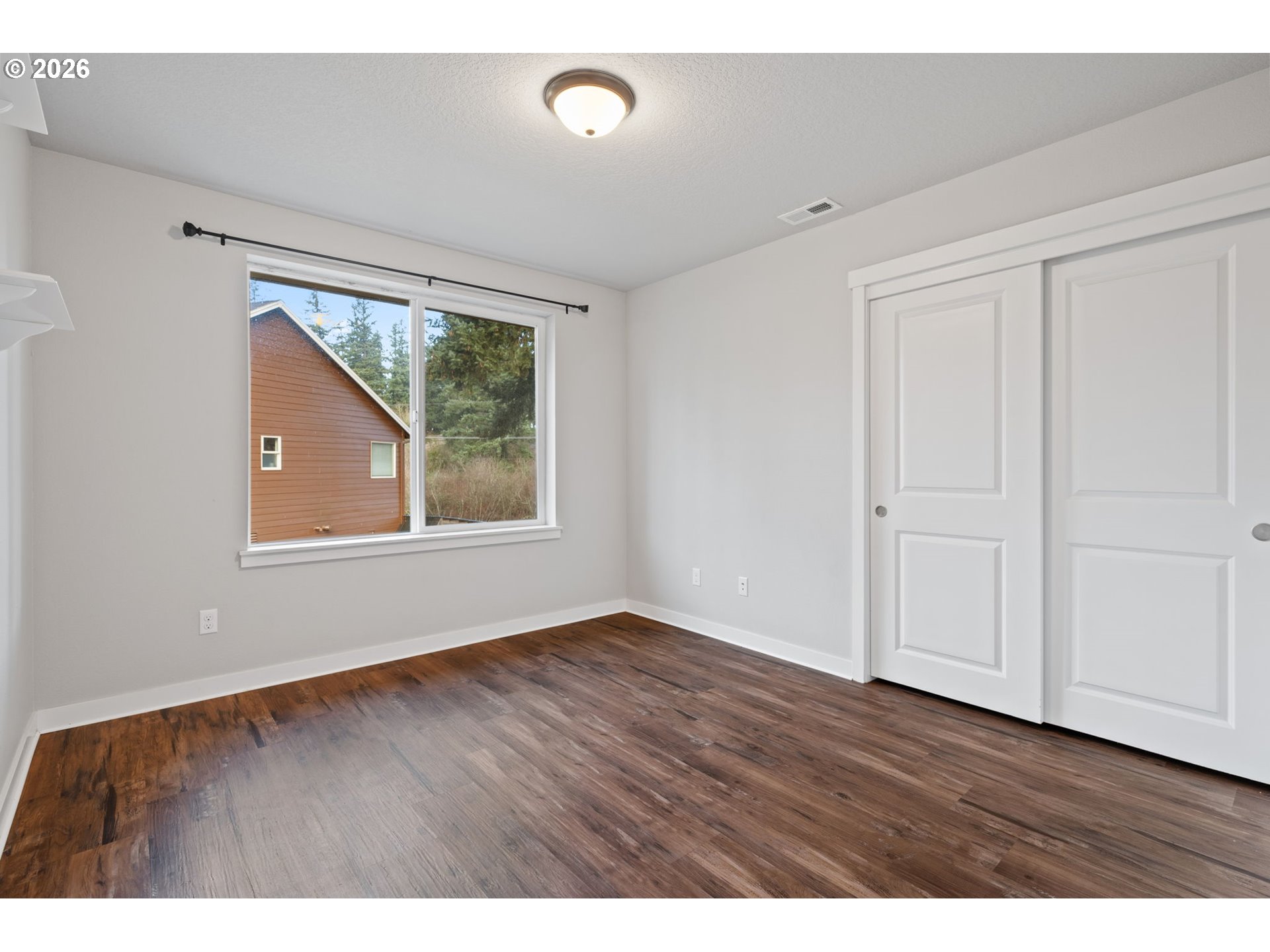 5706 Southeast 134th Place Portland, OR 97236 - Photo 29 of 39 a view of an empty room with wooden floor and a window
