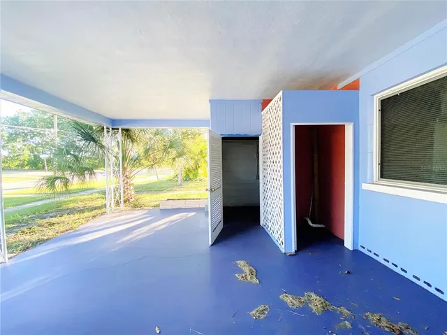 a view of a livingroom with a chandelier fan and kitchen area