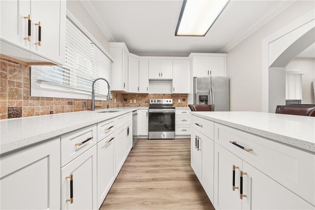 7445 Talbot Colony Northeast Atlanta, GA 30328 - Photo 15 of 41 a large white kitchen with stainless steel appliances lots of counter space and a sink