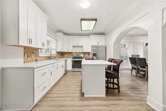 a kitchen with white cabinets and sink
