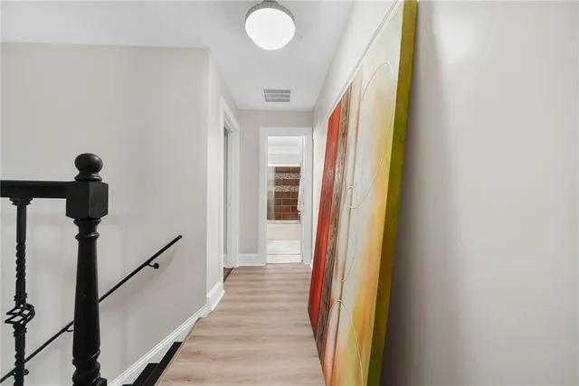 a view of a hallway with wooden floor and staircase