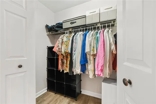 a view of walk in closet with clothes and shoes