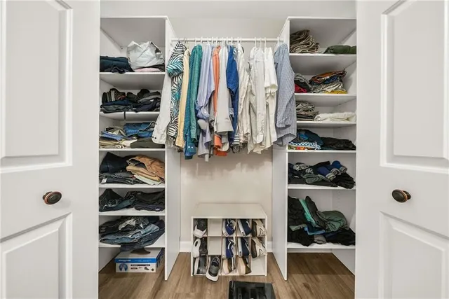 a view of walk in closet with clothes and shoes