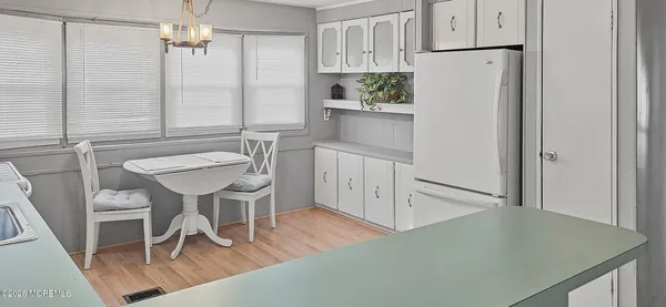 a kitchen with a table chairs refrigerator and cabinets