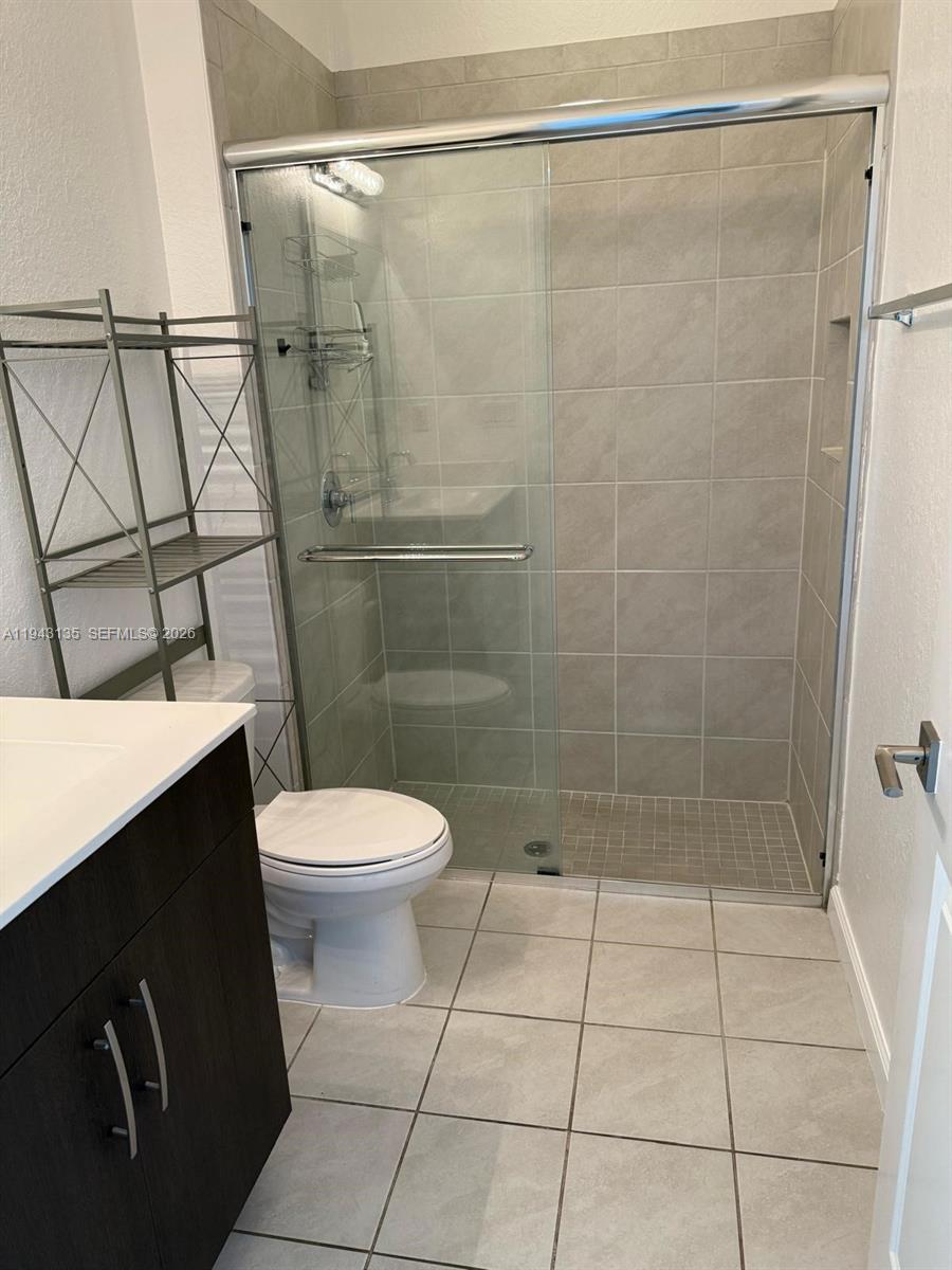 13280 Southwest 272nd Street, Unit 1 Homestead, FL 33032 - Photo 4 of 7 a bathroom with a toilet a sink and shower