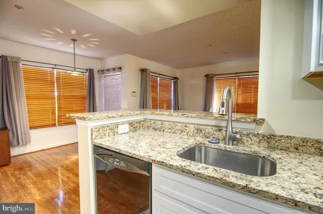 a view with granite countertop a sink and a window